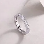 Anillo con diamantes engastados en canal en plata de ley con diseño eterno.