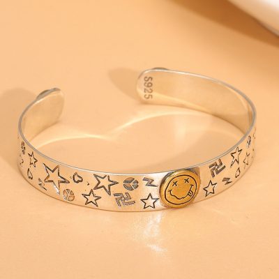 Sterling silver bangle bracelet, three gold-tone happy smile faces engraved on the bracelet.