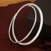 Conjunto de brazalete cuadrado de plata con trébol grabado y brazalete redondo pulido.