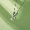 Primer plano del colgante de conejito de jade tallado a mano y luna de plata pulida, un collar de plata único para mujer.