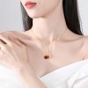 Mujer luciendo el colgante "Lunar Grace" de ágata roja con forma de conejo y luna, chapado en oro de 18 quilates.
