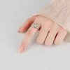 Primer plano de una mujer luciendo el anillo giratorio de plata con forma de trébol, que muestra su elegante ajuste y el brillante detalle de moissanita.