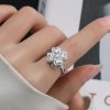 Mujer elegante con un anillo giratorio de plata de ley, un anillo antiestrés con forma de flor de la suerte para aliviar la ansiedad. Color plata.