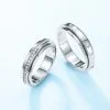 Conjunto de anillos giratorios de moissanita plateada para él y para ella, fotografía de primer plano sobre fondo blanco.