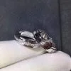 Conjunto de anillos giratorios de moissanita plateada para él y para ella, fotografía de primer plano sobre fondo blanco.