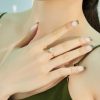 Primer plano de una mujer que luce el anillo giratorio de plata con forma de flor, mostrando su brillante halo de circonitas y su elegante diseño de banda abierta.
