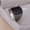 925 sterling silver men's signet ring featuring a polished square black agate stone and engraved side patterns, displayed in a gray jewelry box