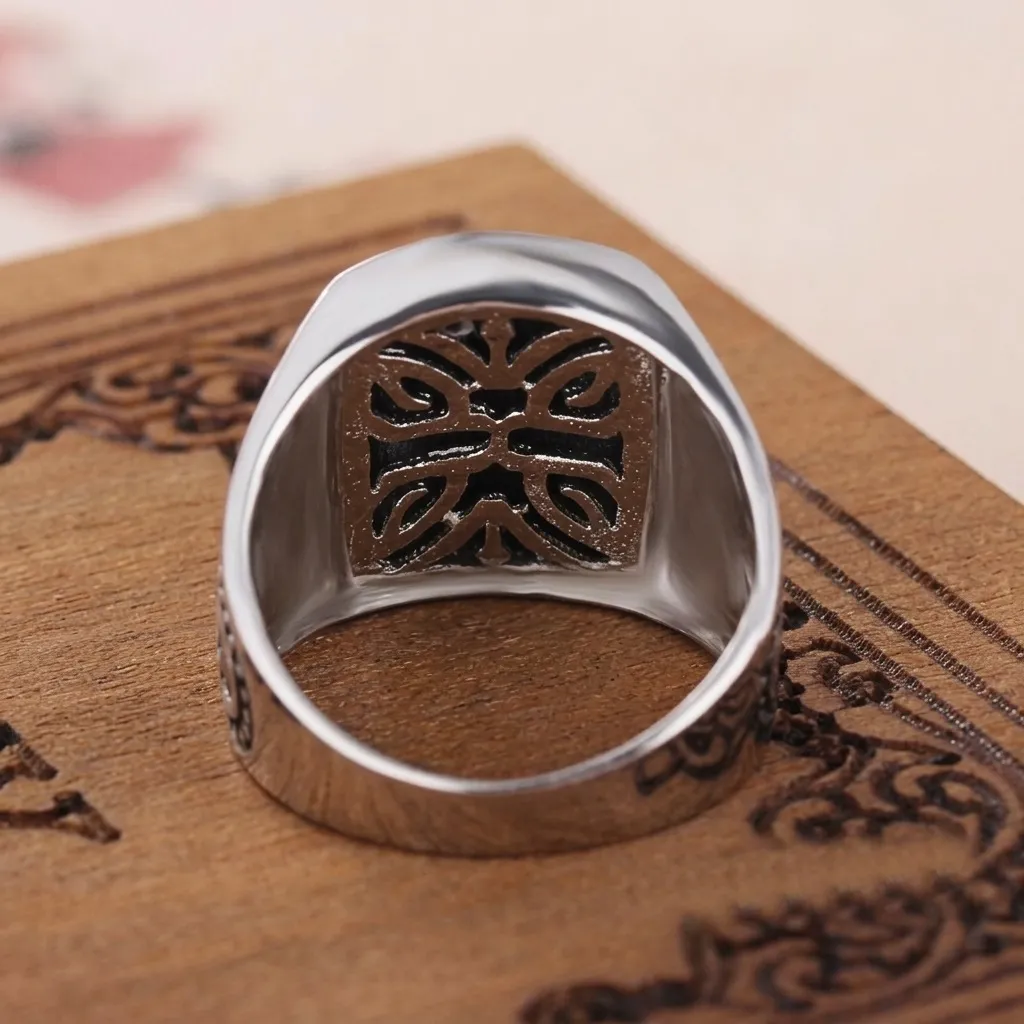 Interior view of a handcrafted men's 925 sterling silver signet ring showing intricate engraved filigree craftsmanship on a wooden surface.